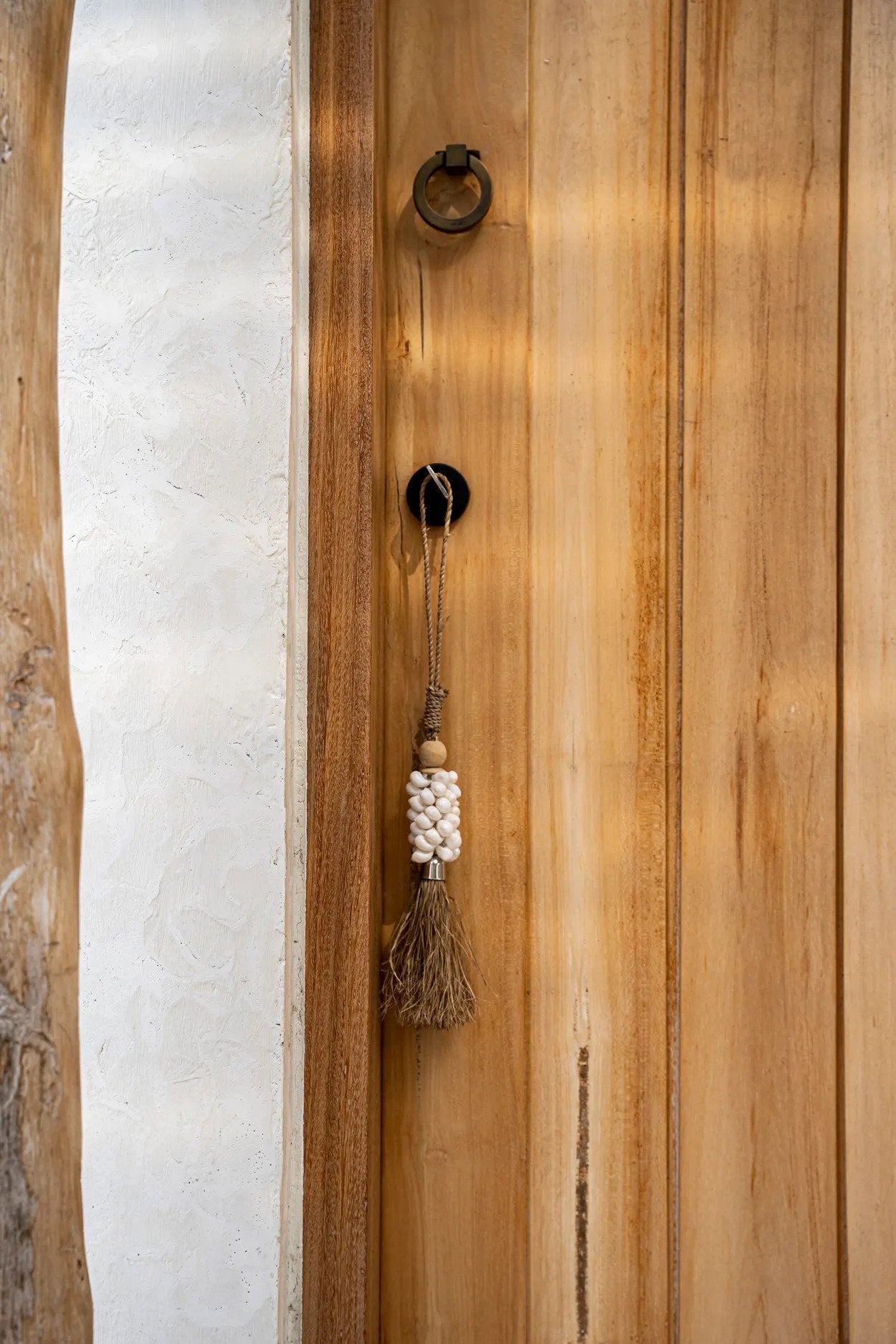 Die Hängedekoration aus Kaurischnecken und Raffia